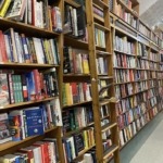 An independent bookstore in Maine. Pictured is a long aisle of books and a stepladder to reach the ones up high. 
