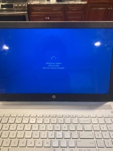 Laptop with a blue screen indicating an update is being done. 